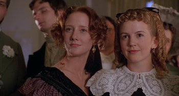 Movie still from “The Adventures of Huck Finn” (1993), directed by Stephen Sommers – Two women are standing in front of other people; Close Up shot, Low angle