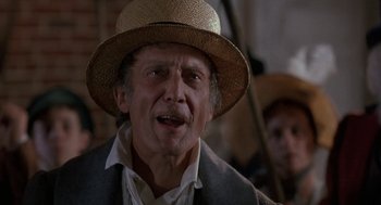 Movie still from “The Adventures of Huck Finn” (1993), directed by Stephen Sommers – An older man wearing a straw hat and a suit; Close Up shot, Low angle