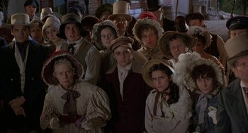 Movie still from “The Adventures of Huck Finn” (1993), directed by Stephen Sommers – A group of people wearing hats and standing in a room; Medium shot, High angle