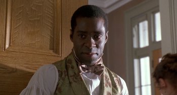Movie still from “The Adventures of Huck Finn” (1993), directed by Stephen Sommers – A man wearing a bow tie and a vest; Close Up shot, Low angle