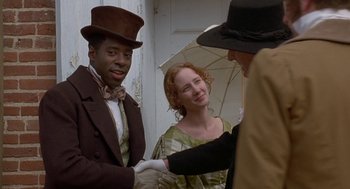 Movie still from “The Adventures of Huck Finn” (1993), directed by Stephen Sommers – A man and a woman are shaking hands with another man; Medium shot, Over the shoulder angle