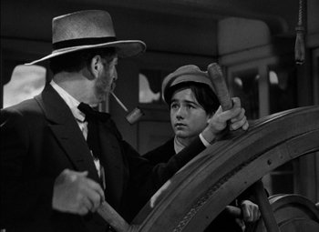 Movie still from “The Adventures of Mark Twain” (1944), directed by Irving Rapper – A man and a boy in a suit and hat; Medium shot, High angle