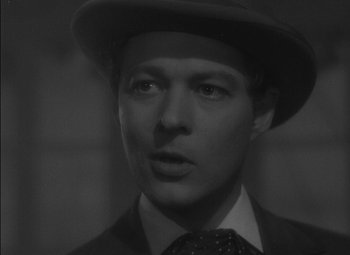 Movie still from “The Adventures of Mark Twain” (1944), directed by Irving Rapper – A black and white photo of a man wearing a suit and hat; Close Up shot, Over the shoulder angle