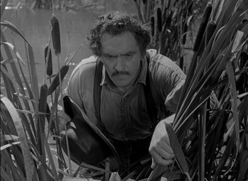 Movie still from “The Adventures of Mark Twain” (1944), directed by Irving Rapper – A black and white photo of a man kneeling in a field; Medium shot, High angle