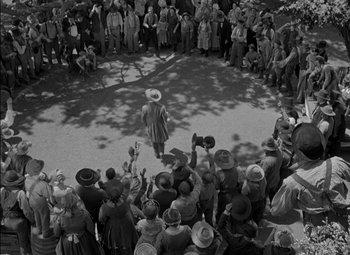 Movie still from “The Adventures of Mark Twain” (1944), directed by Irving Rapper – A crowd of people gathered in a circle to watch a woman in a hat dance; Extreme Wide shot, High angle
