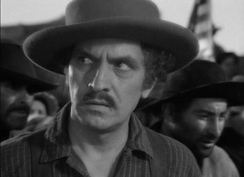 Movie still from “The Adventures of Mark Twain” (1944), directed by Irving Rapper – A black and white photo of a man in a hat; Close Up shot, Over the shoulder angle
