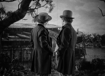 Movie still from “The Adventures of Mark Twain” (1944), directed by Irving Rapper – Two men in coats and hats looking out over a river; Wide shot, Over the shoulder angle
