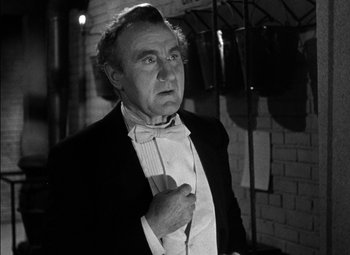 Movie still from “The Adventures of Mark Twain” (1944), directed by Irving Rapper – An older man wearing a tuxedo and bow tie in front of a brick wall; Close Up shot, Low angle