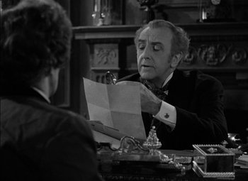 Movie still from “The Adventures of Mark Twain” (1944), directed by Irving Rapper – An older man sitting at a desk looking at a piece of paper; Close Up shot, Over the shoulder angle