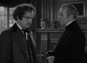 Movie still from “The Adventures of Mark Twain” (1944), directed by Irving Rapper – Two men in suits talking to each other in front of a fireplace; Medium shot, Over the shoulder angle
