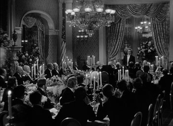 Movie still from “The Adventures of Mark Twain” (1944), directed by Irving Rapper – A black and white photo of people sitting at a table; Wide shot, High angle
