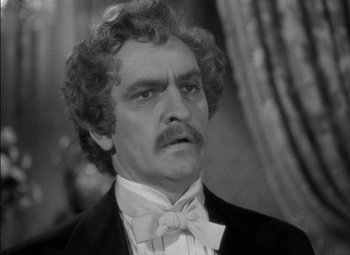 Movie still from “The Adventures of Mark Twain” (1944), directed by Irving Rapper – A man in a suit and bow tie; Close Up shot, High angle