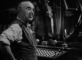 Movie still from “The Adventures of Mark Twain” (1944), directed by Irving Rapper – An older man standing in front of a machine; Close Up shot, Low angle