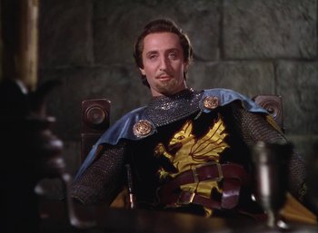 Movie still from “The Adventures of Robin Hood” (1938), directed by William Keighley – A man wearing a knight's outfit sitting in a chair; Medium shot, Low angle
