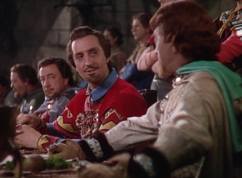 Movie still from “The Adventures of Robin Hood” (1938), directed by William Keighley – A group of people sitting around a table; Medium shot, Over the shoulder angle