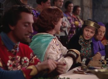 Movie still from “The Adventures of Robin Hood” (1938), directed by William Keighley – A group of people sitting around a table; Medium shot, Over the shoulder angle