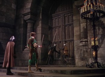 Movie still from “The Adventures of Robin Hood” (1938), directed by William Keighley – A group of people standing in front of a building; Wide shot, High angle
