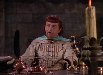 Movie still from “The Adventures of Robin Hood” (1938), directed by William Keighley – A man sitting at a dining table with a lot of copper utensils on the table; Medium shot, High angle