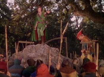 Movie still from “The Adventures of Robin Hood” (1938), directed by William Keighley – A man dressed as robin hood on a stage; Wide shot, High angle