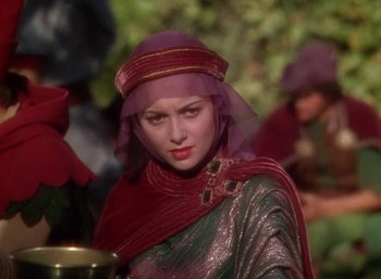 Movie still from “The Adventures of Robin Hood” (1938), directed by William Keighley – A woman wearing a red veil and a silver outfit; Close Up shot, Over the shoulder angle