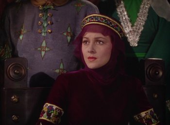 Movie still from “The Adventures of Robin Hood” (1938), directed by William Keighley – A woman in a red dress and a purple turban; Medium shot, Low angle