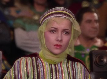 Movie still from “The Adventures of Robin Hood” (1938), directed by William Keighley – A woman in a colorful dress with a yellow headscarf; Close Up shot, Low angle