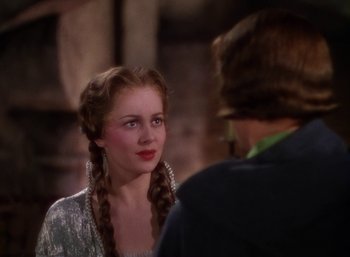 Movie still from “The Adventures of Robin Hood” (1938), directed by William Keighley – A young woman with long braids talking to an older man; Close Up shot, Over the shoulder angle