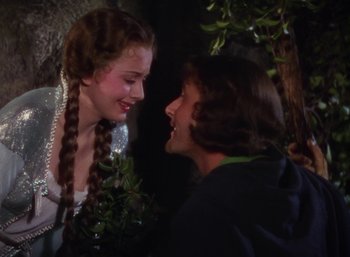 Movie still from “The Adventures of Robin Hood” (1938), directed by William Keighley – A woman and a man are smiling at each other; Medium shot, High angle