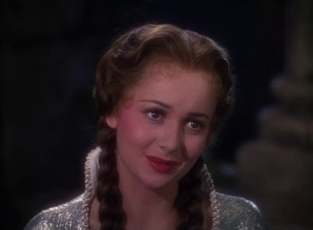 Movie still from “The Adventures of Robin Hood” (1938), directed by William Keighley – A woman with long braids wearing a silver dress; Close Up shot, Over the shoulder angle