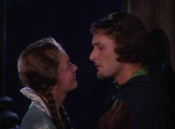 Movie still from “The Adventures of Robin Hood” (1938), directed by William Keighley – A man and a woman face to face in front of a dark background; Close Up shot, Over the shoulder angle