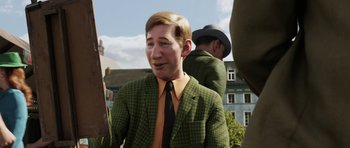 Movie still from “The Adventures of Tintin” (2011), directed by Steven Spielberg – A man wearing a green suit and orange tie; Close Up shot, Over the shoulder angle