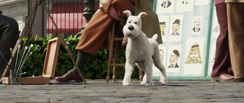 Movie still from “The Adventures of Tintin” (2011), directed by Steven Spielberg – A small white dog standing next to a person; Wide shot, Low angle