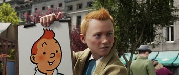Movie still from “The Adventures of Tintin” (2011), directed by Steven Spielberg – A young man holding a picture of a cartoon character; Close Up shot, High angle