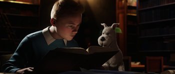 Movie still from “The Adventures of Tintin” (2011), directed by Steven Spielberg – A boy and a stuffed dog are reading a book together; Medium shot, Over the shoulder angle