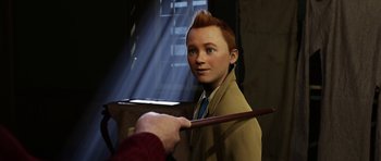 Movie still from “The Adventures of Tintin” (2011), directed by Steven Spielberg – A person holding a wand and a boy in a suit; Medium shot, Over the shoulder angle
