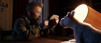 Movie still from “The Adventures of Tintin” (2011), directed by Steven Spielberg – A man sitting at a table with a stuffed animal; Medium shot, Over the shoulder angle
