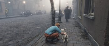 Movie still from “The Adventures of Tintin” (2011), directed by Steven Spielberg – A man kneeling down to pet a dog on a foggy day; Wide shot, High angle