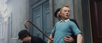 Movie still from “The Adventures of Tintin” (2011), directed by Steven Spielberg – A boy with a red mohawk is standing in front of a man; Medium shot, Over the shoulder angle