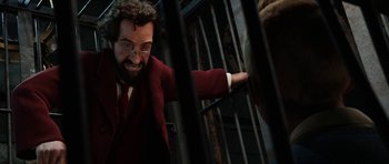 Movie still from “The Adventures of Tintin” (2011), directed by Steven Spielberg – A man in a red suit is behind bars; Close Up shot, Low angle