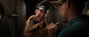 Movie still from “The Adventures of Tintin” (2011), directed by Steven Spielberg – A man wearing a hat and a jacket is talking to another man; Close Up shot, Over the shoulder angle