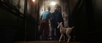 Movie still from “The Adventures of Tintin” (2011), directed by Steven Spielberg – A man and a boy standing next to a sheep; Wide shot, High angle