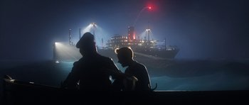 Movie still from “The Adventures of Tintin” (2011), directed by Steven Spielberg – Two people sitting in front of an ocean liner at night; Extreme Wide shot, Low angle