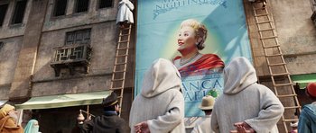 Movie still from “The Adventures of Tintin” (2011), directed by Steven Spielberg – A poster of a woman on the side of a building; Wide shot, Low angle
