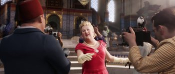 Movie still from “The Adventures of Tintin” (2011), directed by Steven Spielberg – A woman in a red dress is standing in front of a crowd; Medium shot, Over the shoulder angle