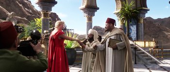 Movie still from “The Adventures of Tintin” (2011), directed by Steven Spielberg – A woman in a red dress and two men in white robes; Wide shot, Over the shoulder angle