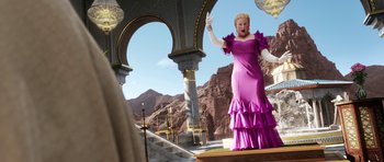 Movie still from “The Adventures of Tintin” (2011), directed by Steven Spielberg – A woman in a purple dress standing in front of a building; Wide shot, Over the shoulder angle