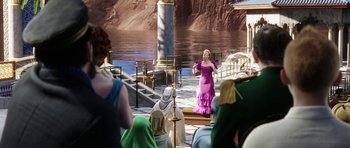 Movie still from “The Adventures of Tintin” (2011), directed by Steven Spielberg – A woman in a purple dress standing in front of a body of water; Wide shot, Over the shoulder angle