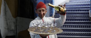 Movie still from “The Adventures of Tintin” (2011), directed by Steven Spielberg – A man holding a tray of wine glasses and a bottle of wine; Close Up shot, High angle