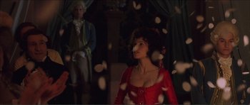 Movie still from “The Affair of the Necklace” (2001), directed by Charles Shyer – A woman in a red dress standing in front of a man; Medium shot, Over the shoulder angle