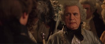 Movie still from “The Affair of the Necklace” (2001), directed by Charles Shyer – An older man with a long white beard holding a walking stick; Close Up shot, Over the shoulder angle